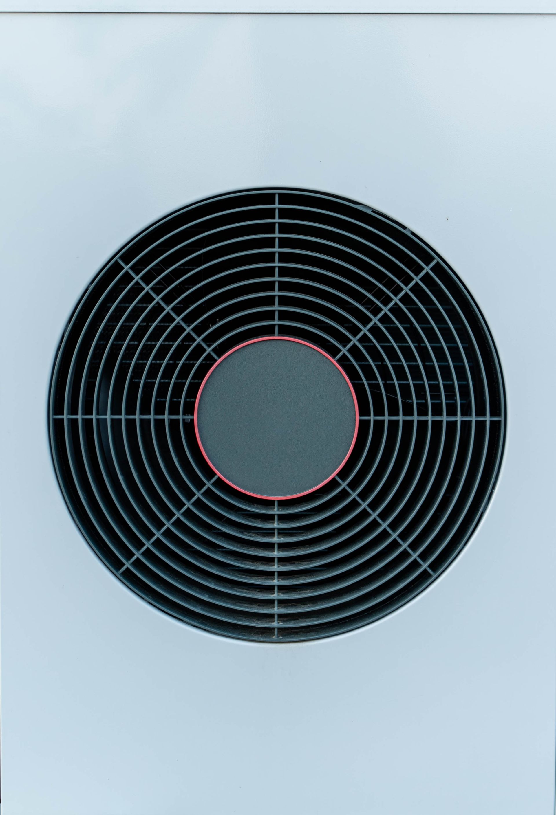 Circular black fan cover on a white surface, with a red ring around the central hub.