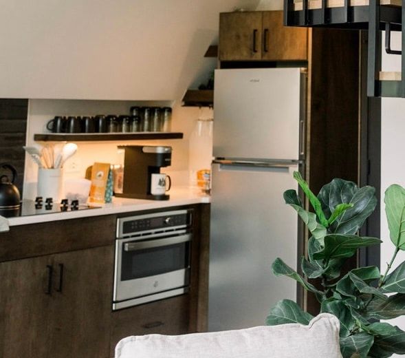 A kitchen with a refrigerator and a couch