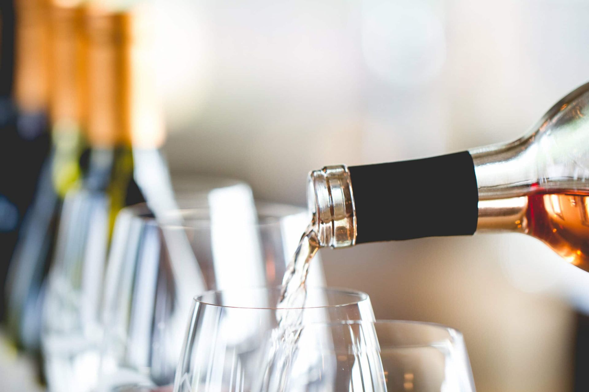 A bottle of wine is being poured into a glass.