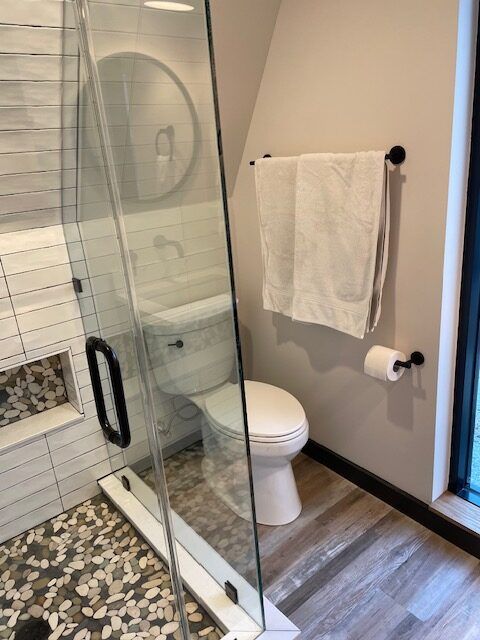 A bathroom with a toilet and a walk in shower