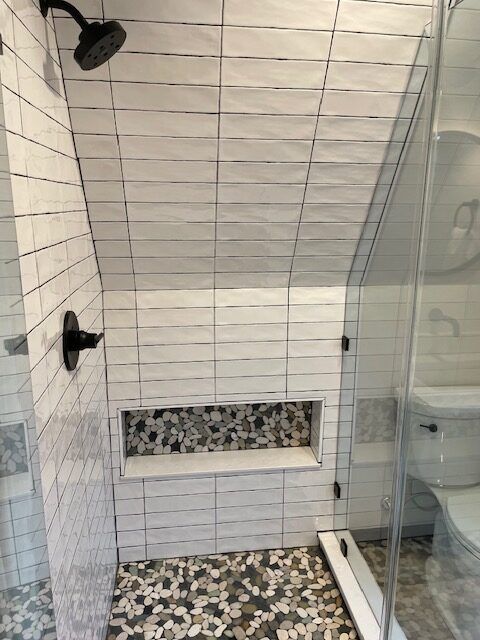 A bathroom with a walk in shower and a toilet.