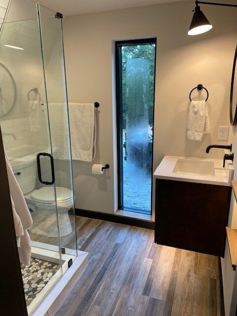 A bathroom with a toilet a sink and a walk in shower