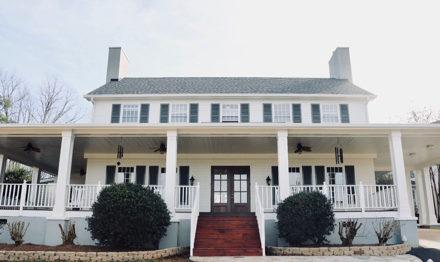 A large white house with a large porch and stairs leading up to it.