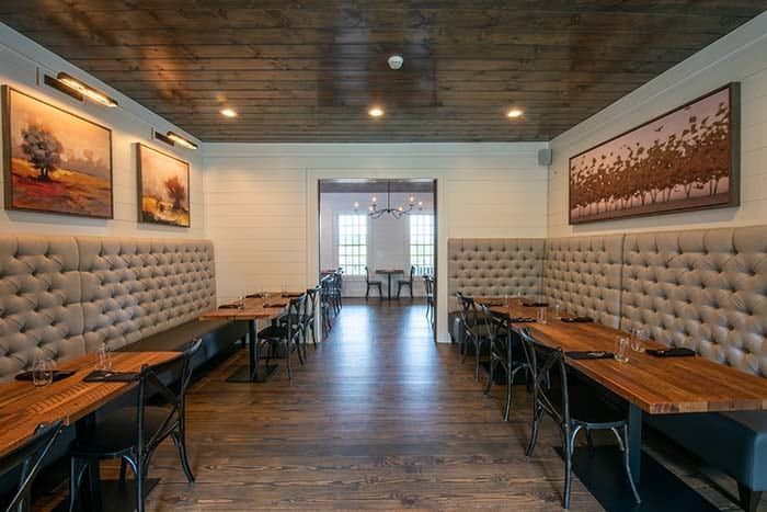 A restaurant with tables and chairs and a painting on the wall.