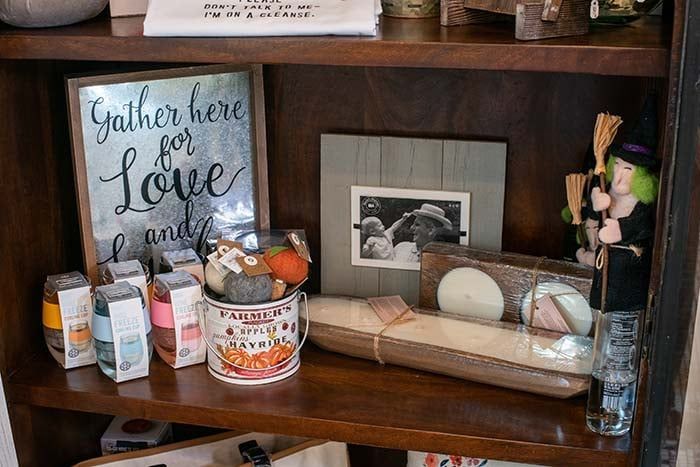 There is a sign on the shelf that says `` gather here for love ''.