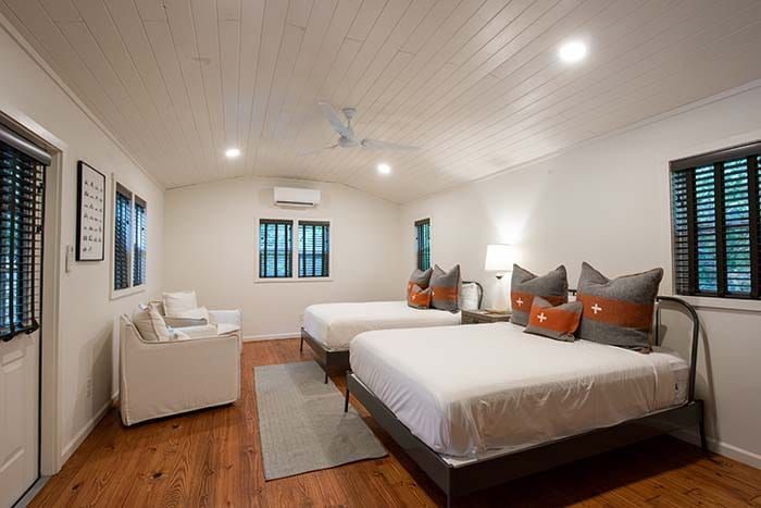 A bedroom with two beds , a couch , and a ceiling fan.