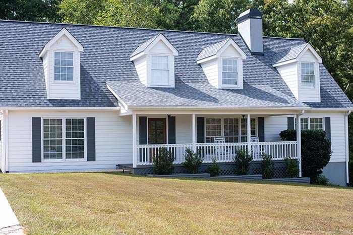 A white house with a blue roof and black shutters