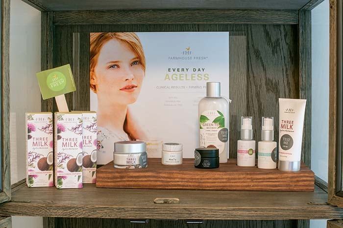 A shelf filled with a variety of cosmetics and a poster of a woman.
