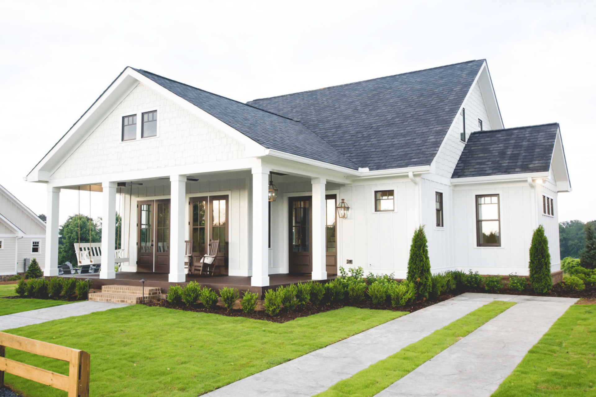 A white house with a black roof and a porch