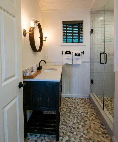 A bathroom with a sink a mirror and a walk in shower