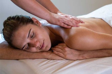A woman is laying on a massage table getting a massage.