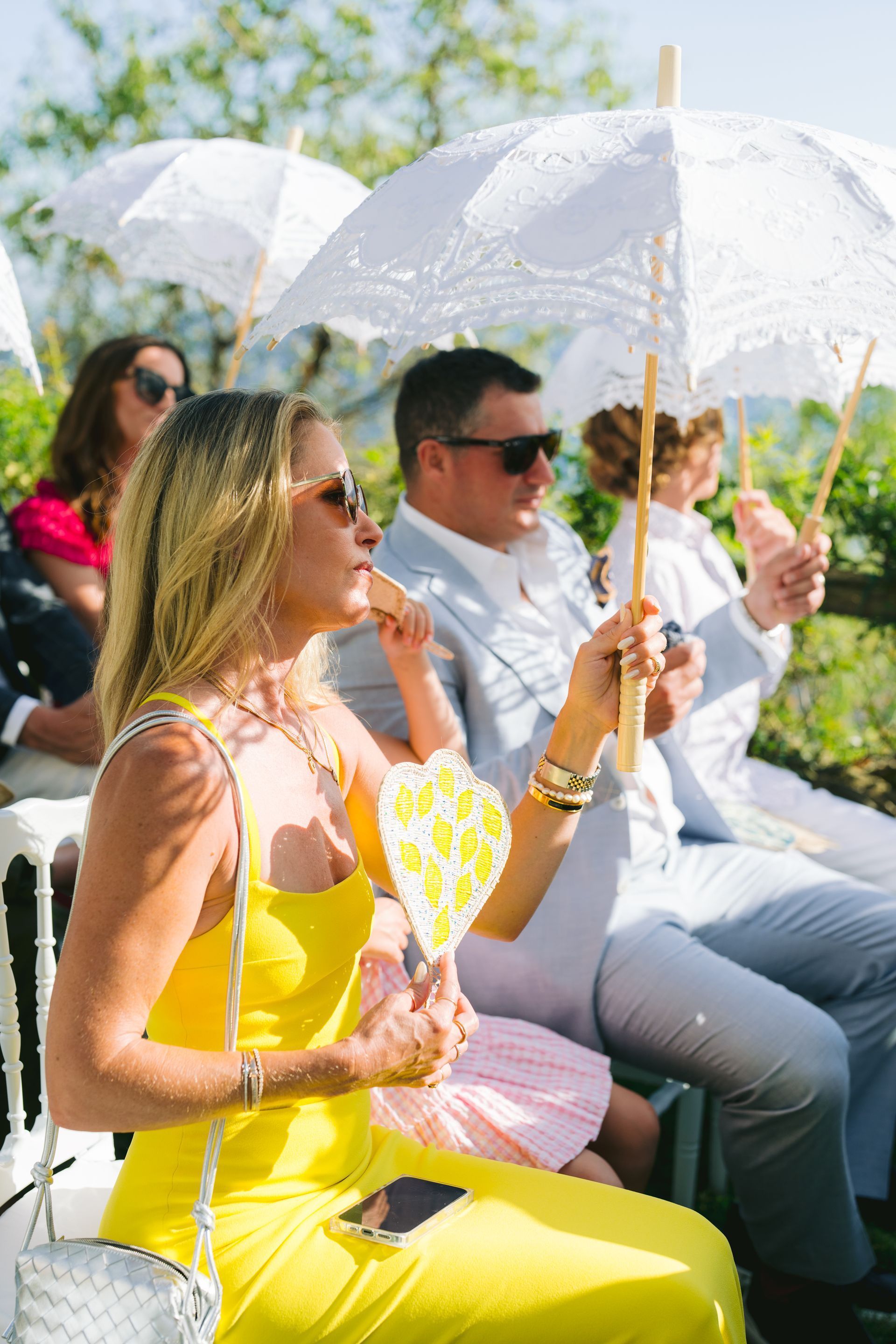A group of people are sitting under white umbrellas.