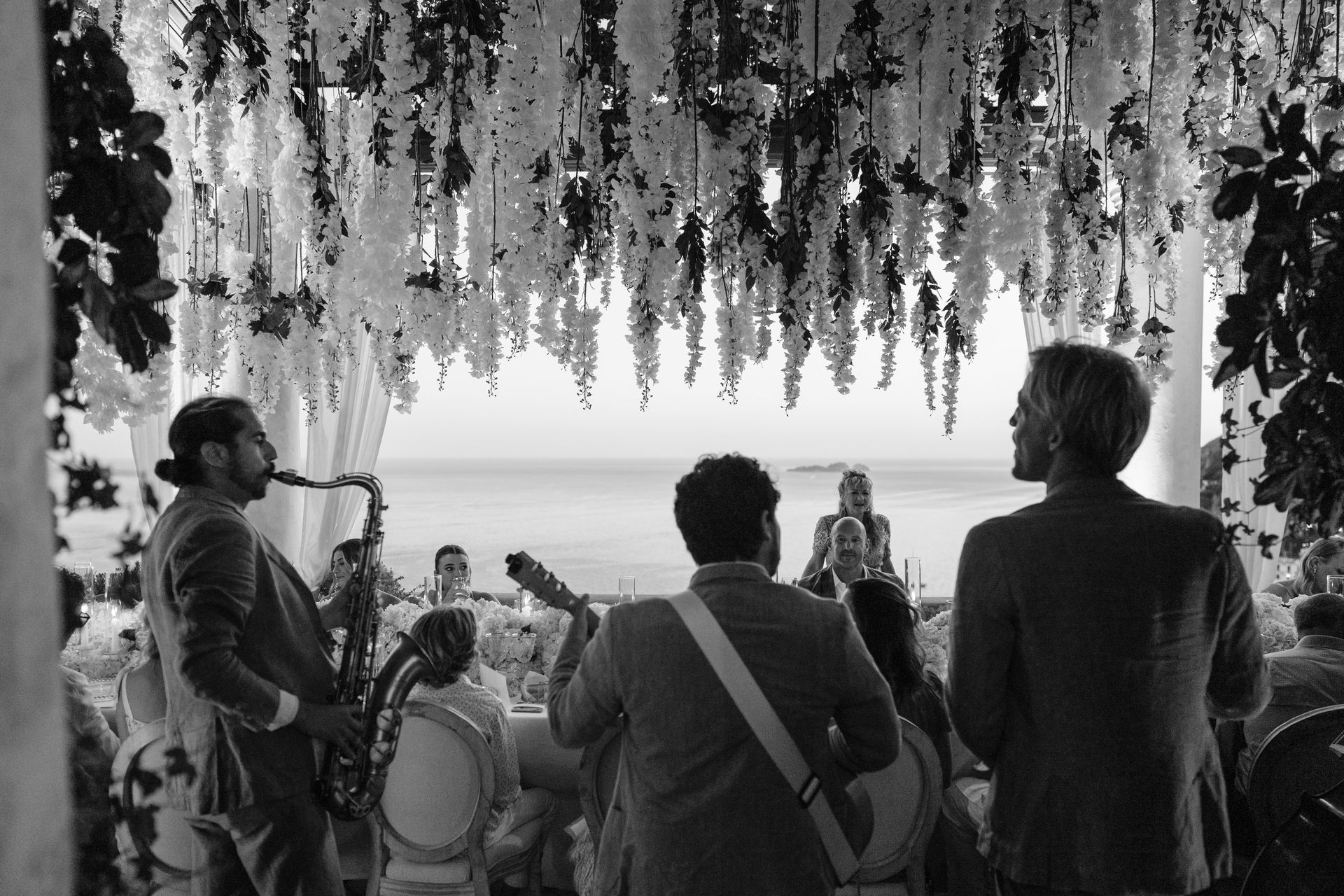 A black and white photo of a band playing music at a wedding reception.