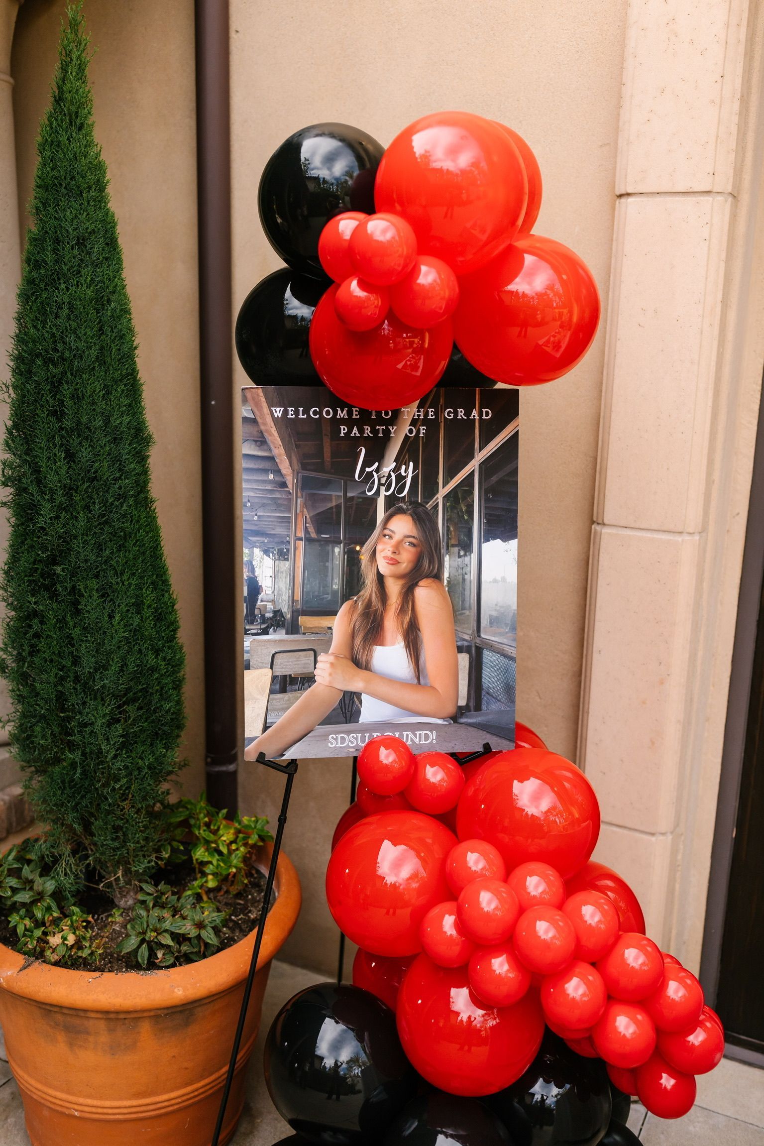 A picture of a woman is surrounded by red and black balloons.