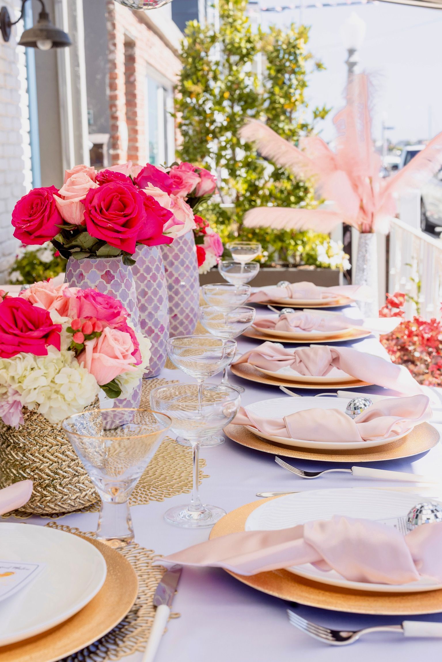 A table with plates , napkins , glasses , and flowers on it.