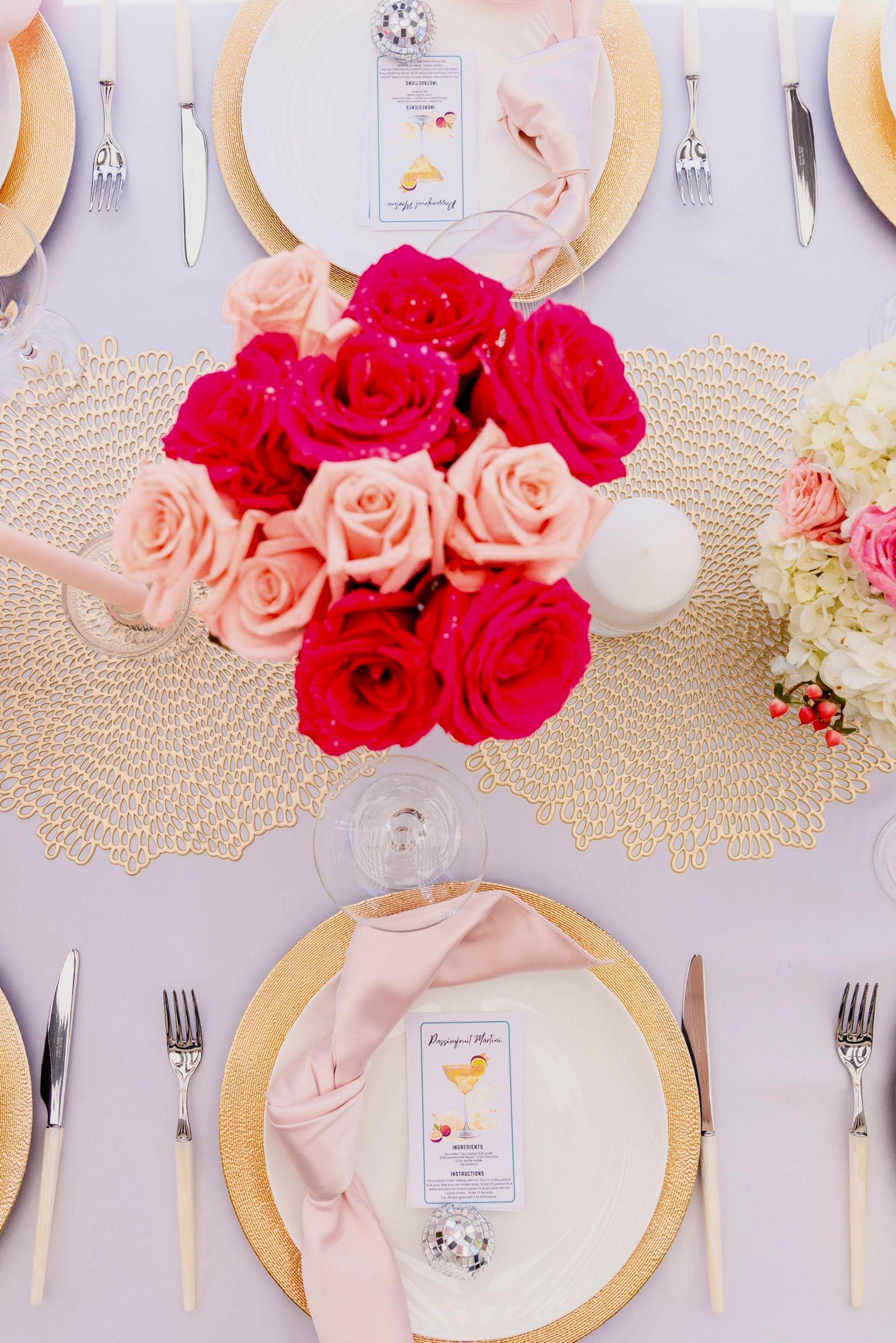 A table with plates , silverware , and flowers on it.
