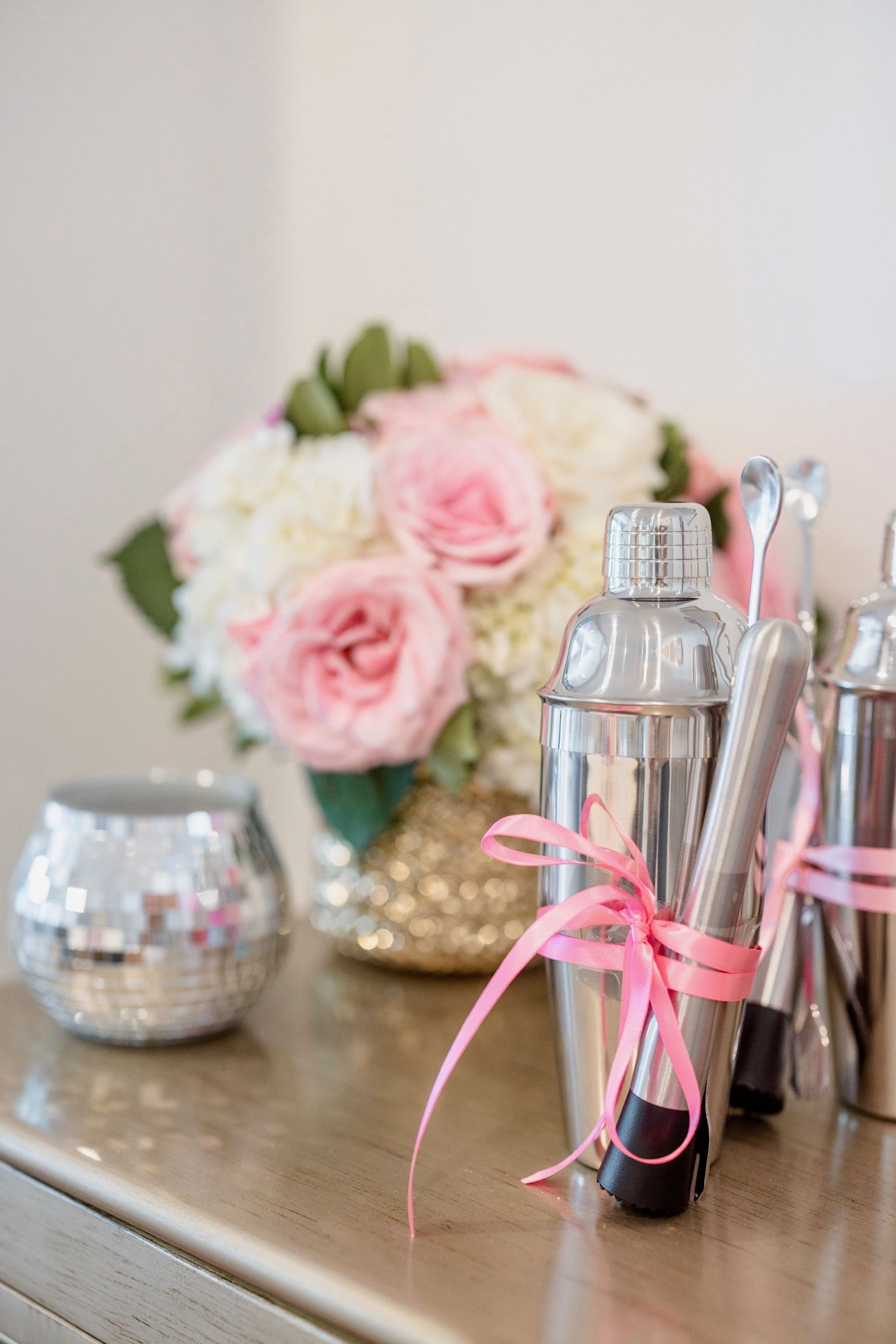 A table with a vase of flowers and a bunch of shakers on it.
