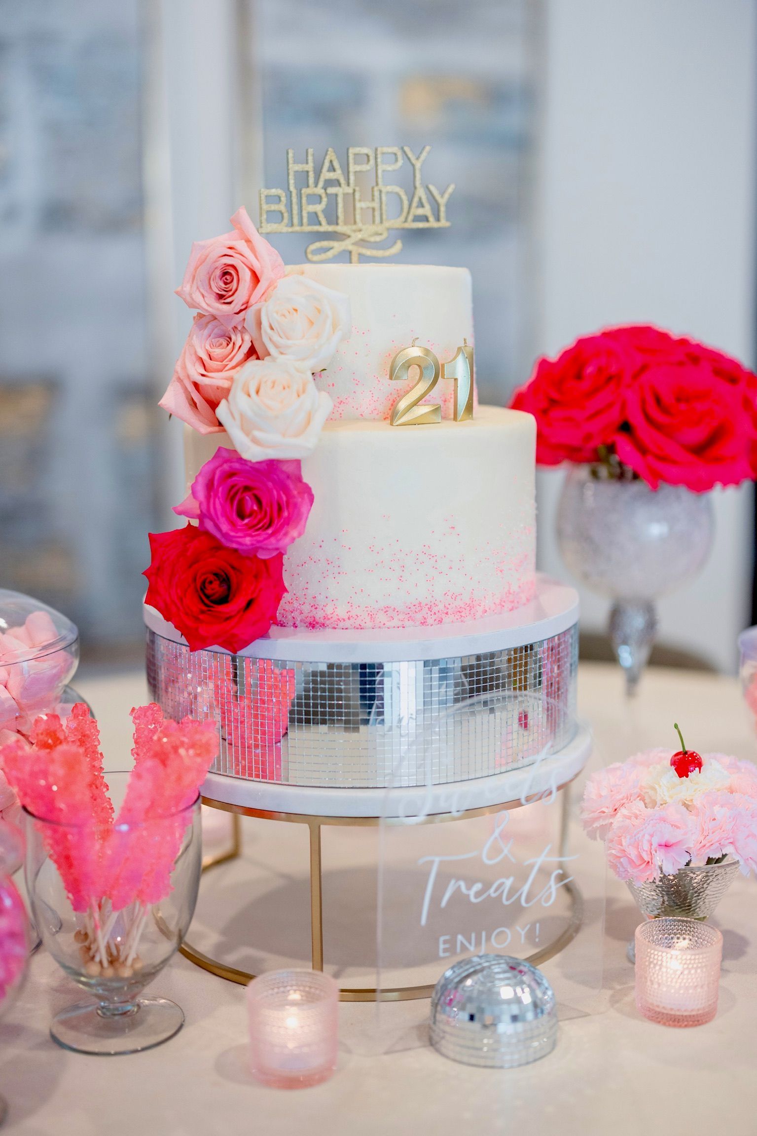 A birthday cake is sitting on top of a table with flowers and candles.