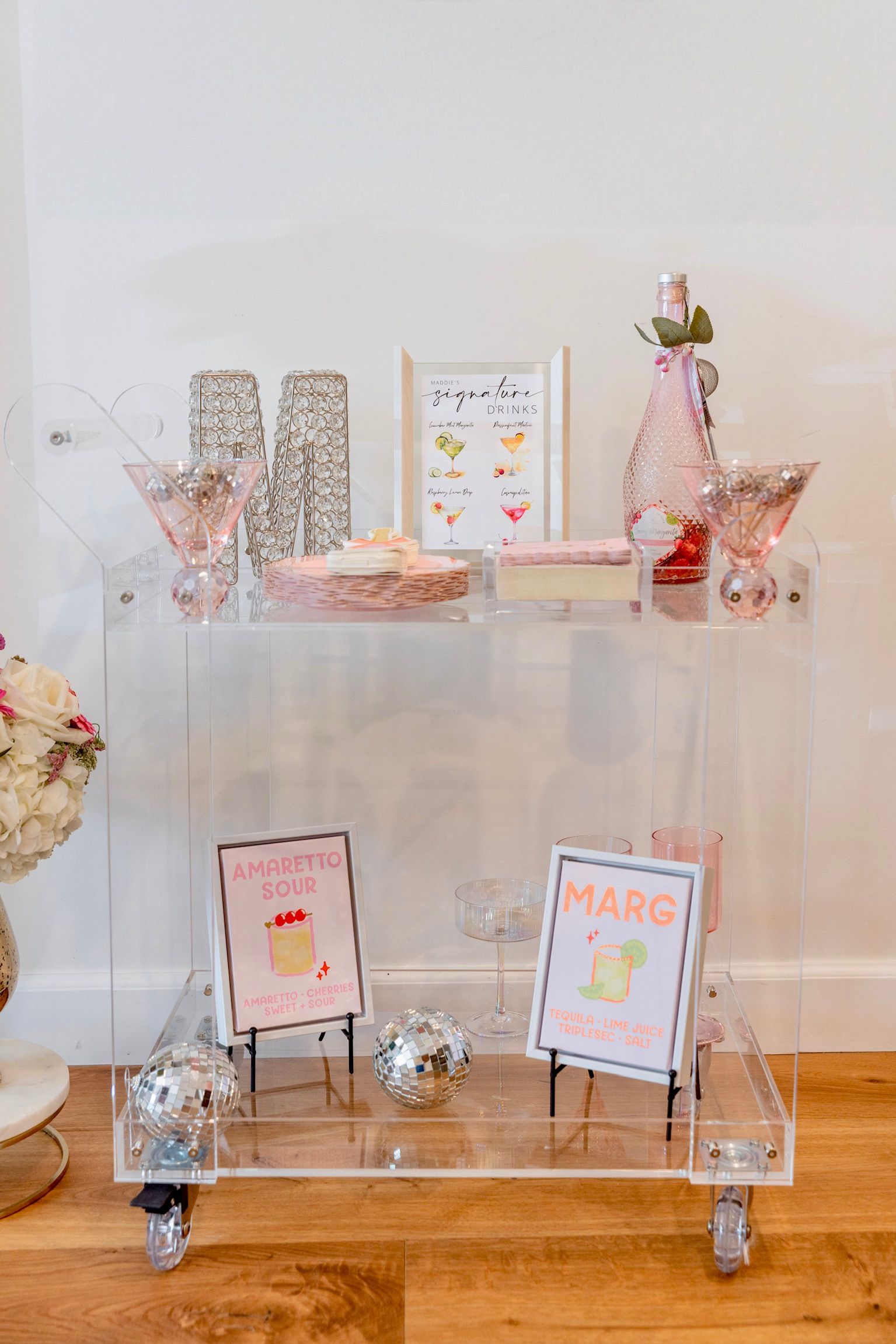 A clear acrylic table with wheels is sitting on a wooden floor.