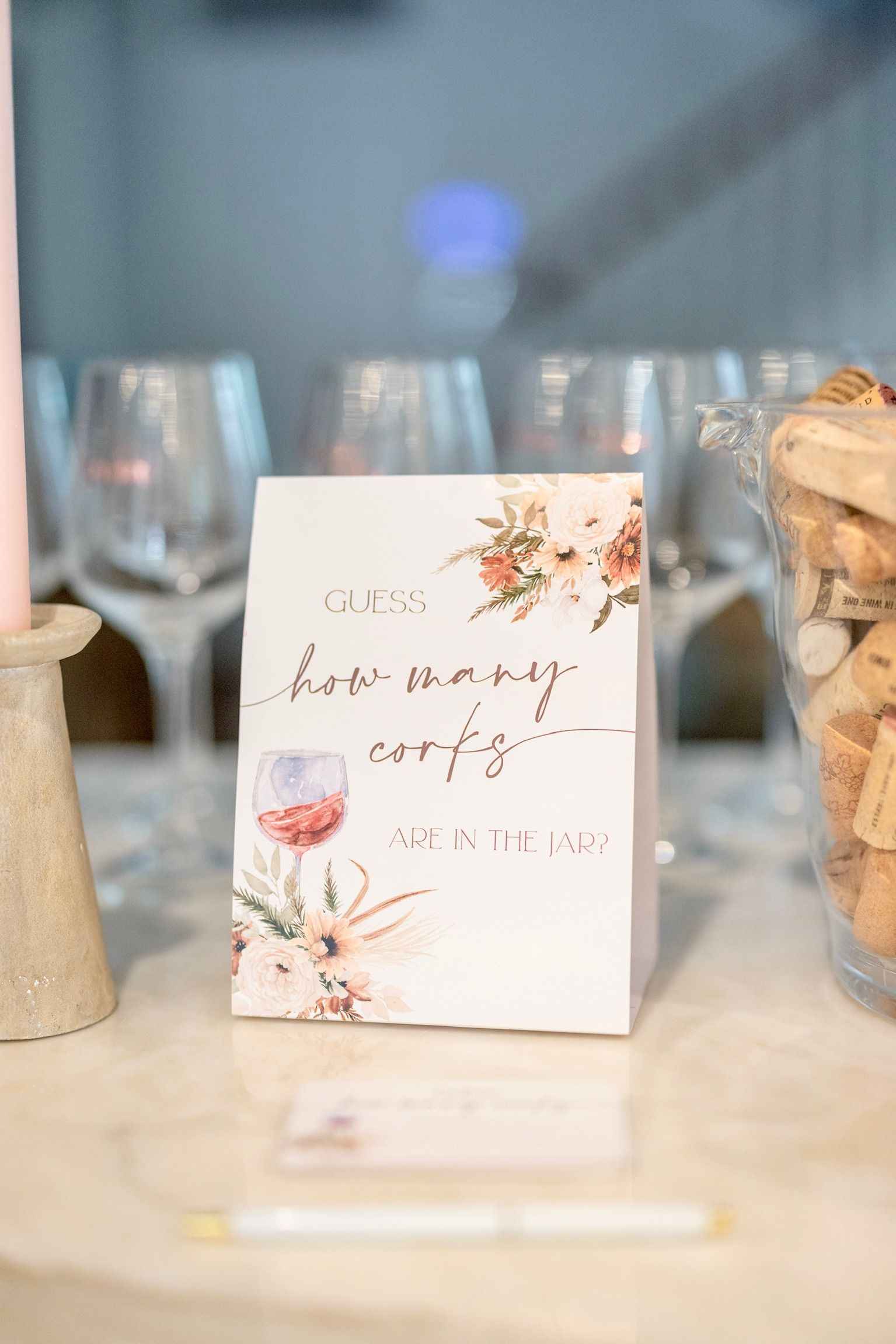 A card with a wine glass on it is sitting on a table next to wine glasses.