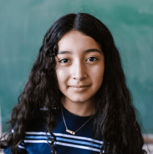 Portrait of a young person with long dark hair against a teal background, wearing a navy striped shirt and necklace