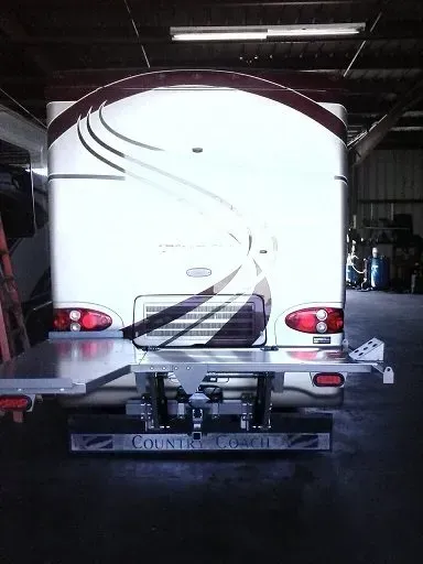 Rear view of a white RV with a raised platform, 