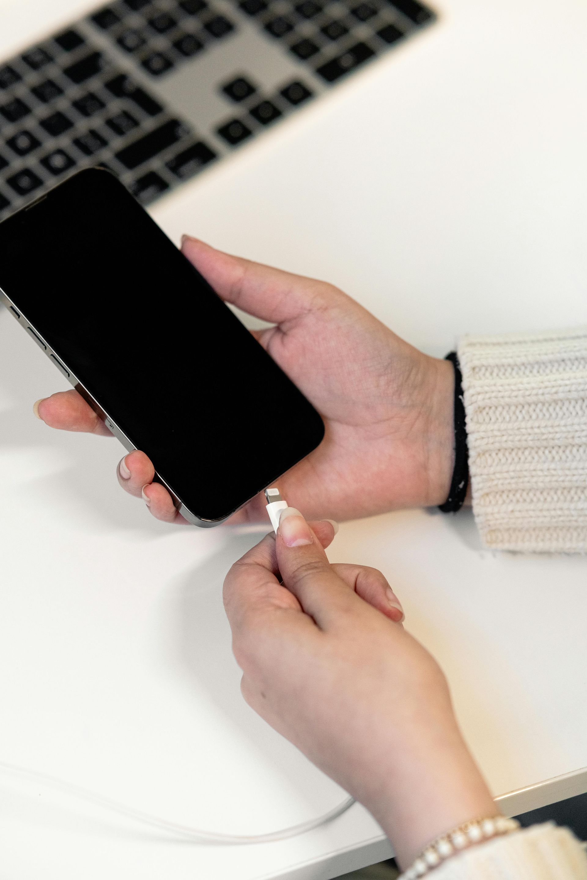 A person is plugging a cell phone into a charger