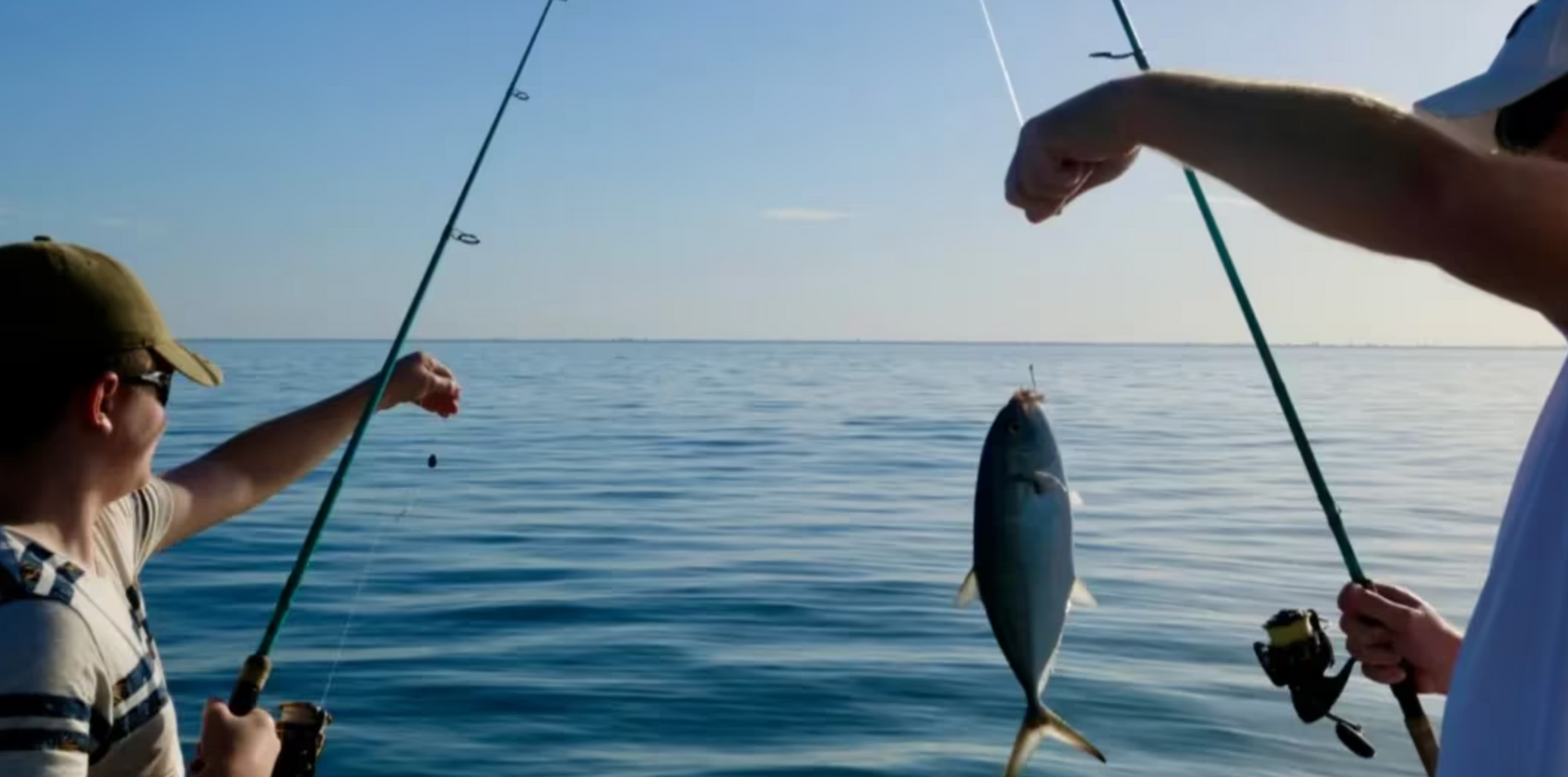 A man and a boy are fishing in the ocean