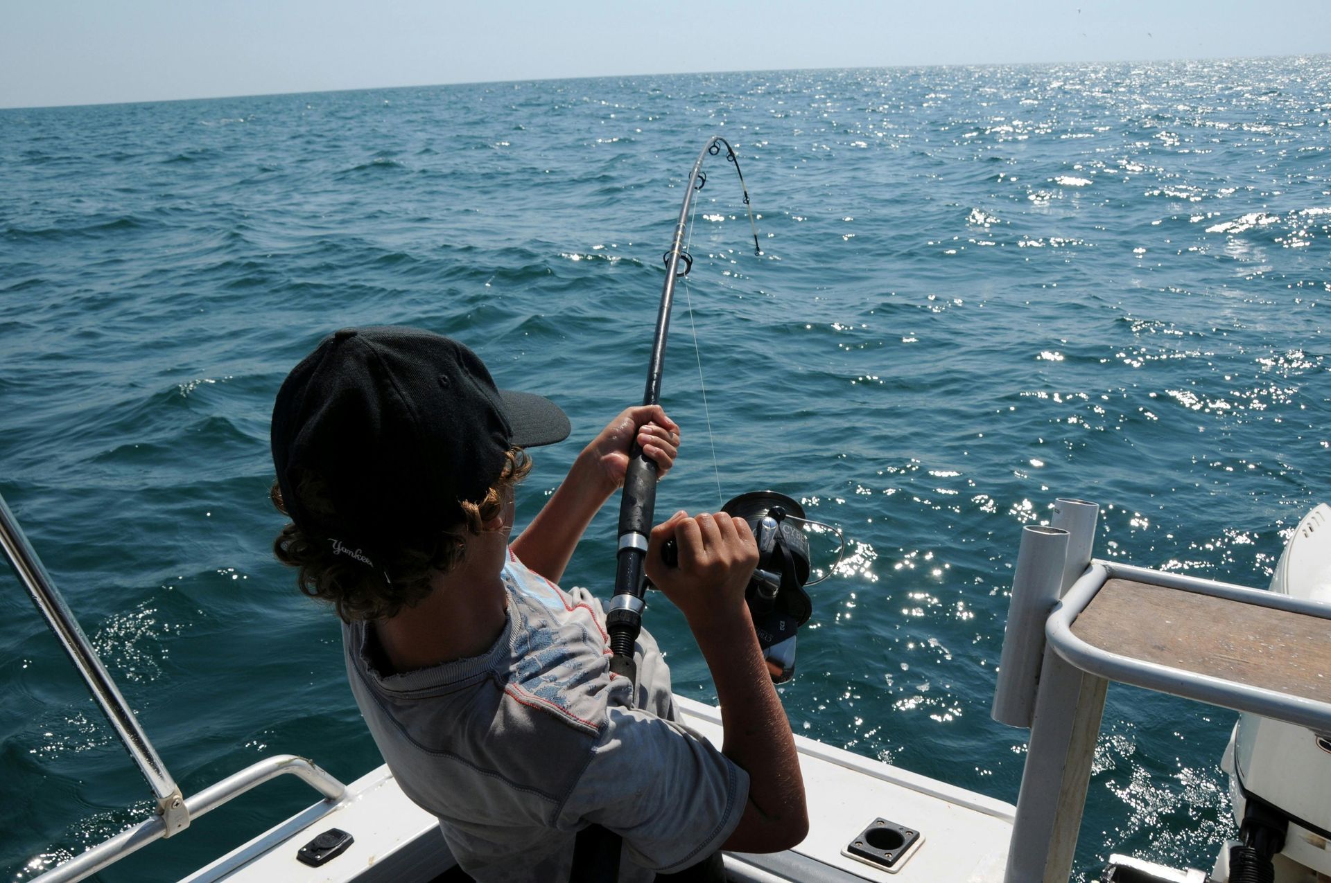 A man and a woman are fishing on a boat.