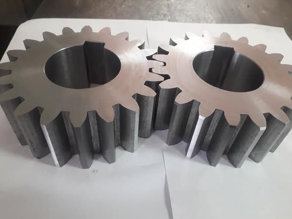 Due ingranaggi metallici con molti denti che si ingranano.