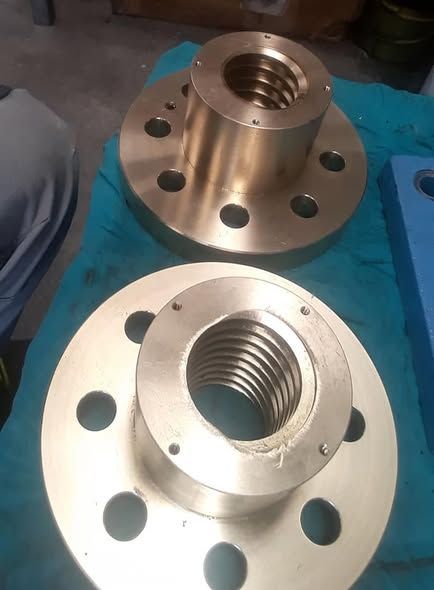 Due flange in bronzo con mozzi centrali filettati e fori per bulloni.