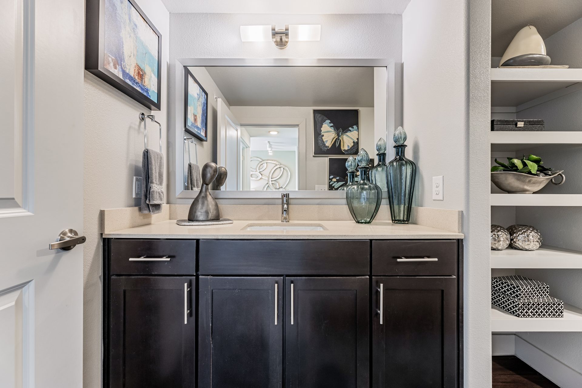 Apartment bathroom with a sink, mirror, and cabinets for storage at Parkside at Craig Ranch.