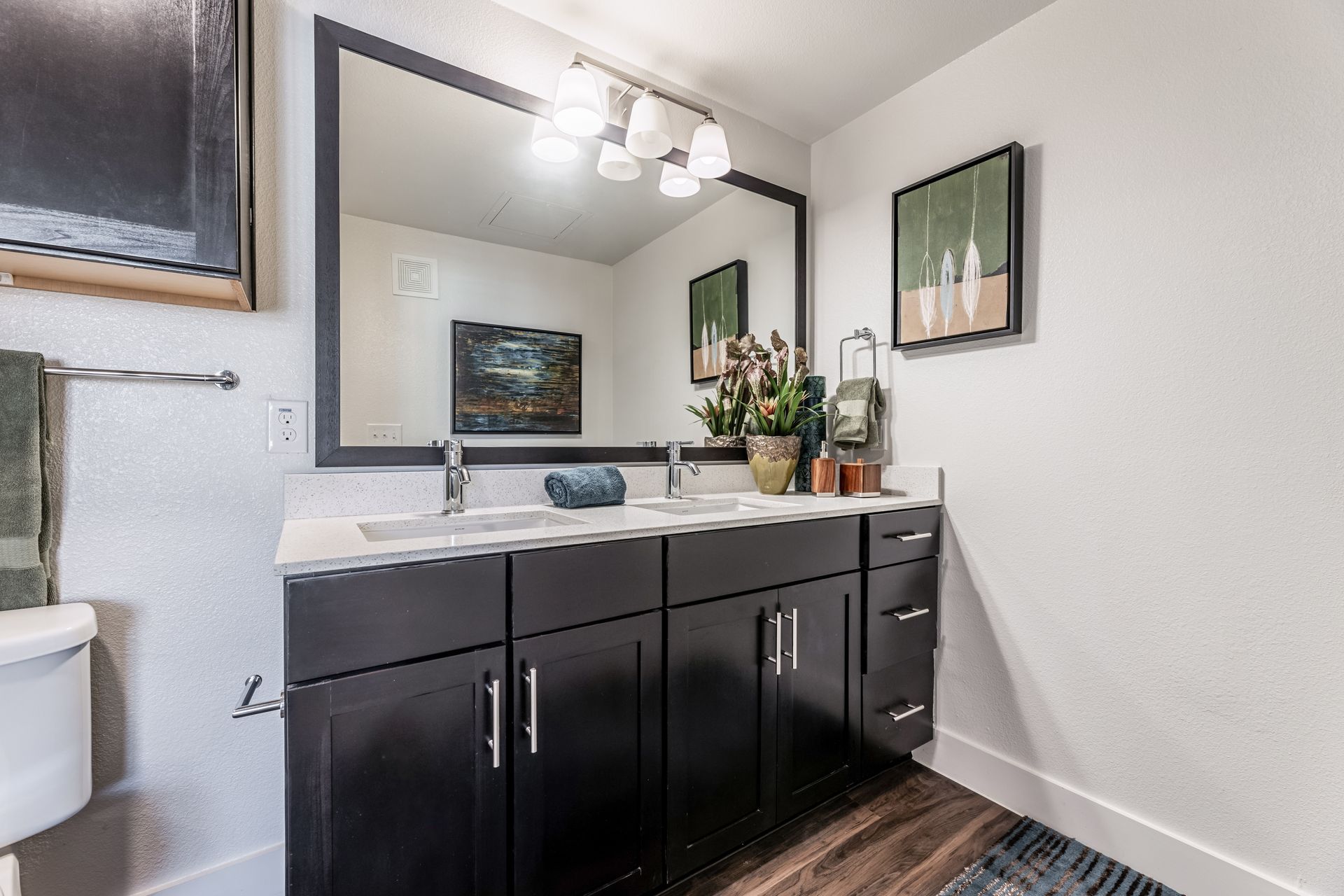 Luxury bathroom with two sinks, a toilet, and a large mirror at Parkside at Craig Ranch.