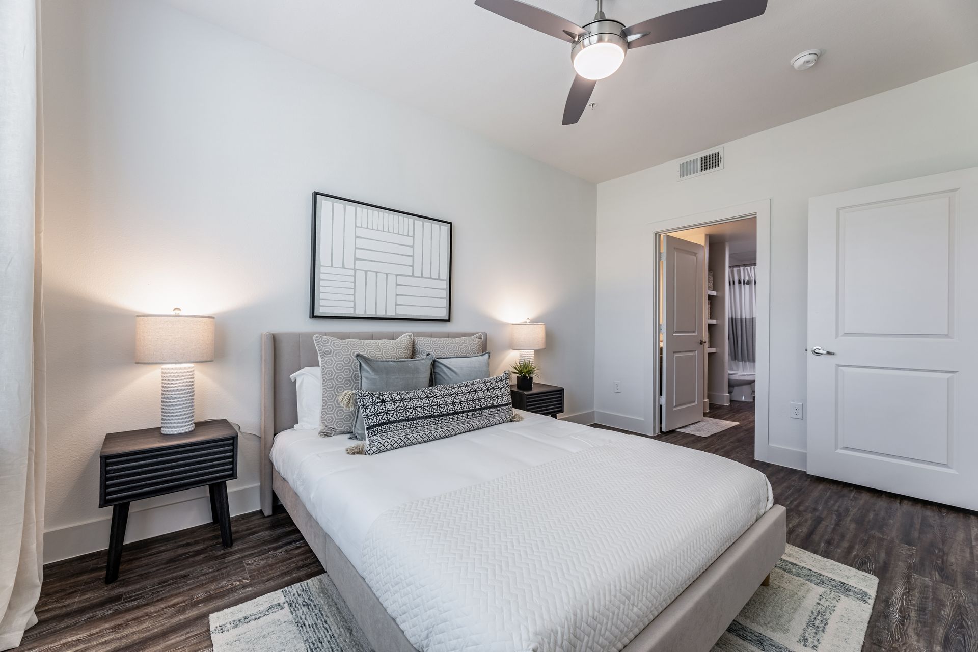Modern bedroom with a large bed and a ceiling fan at Parkside at Craig Ranch.