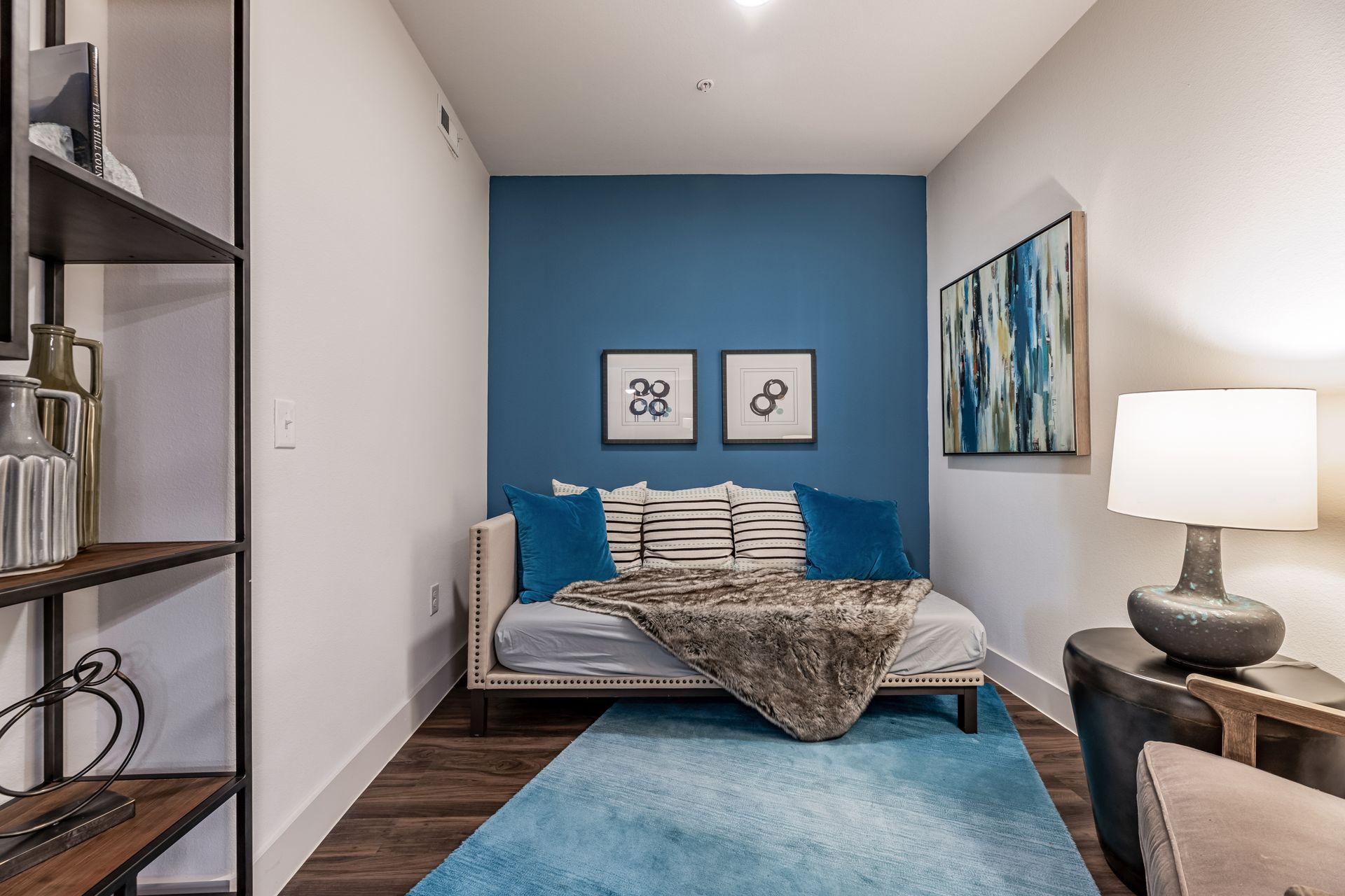 Guest room with a blue wall and a bed at Parkside at Craig Ranch.