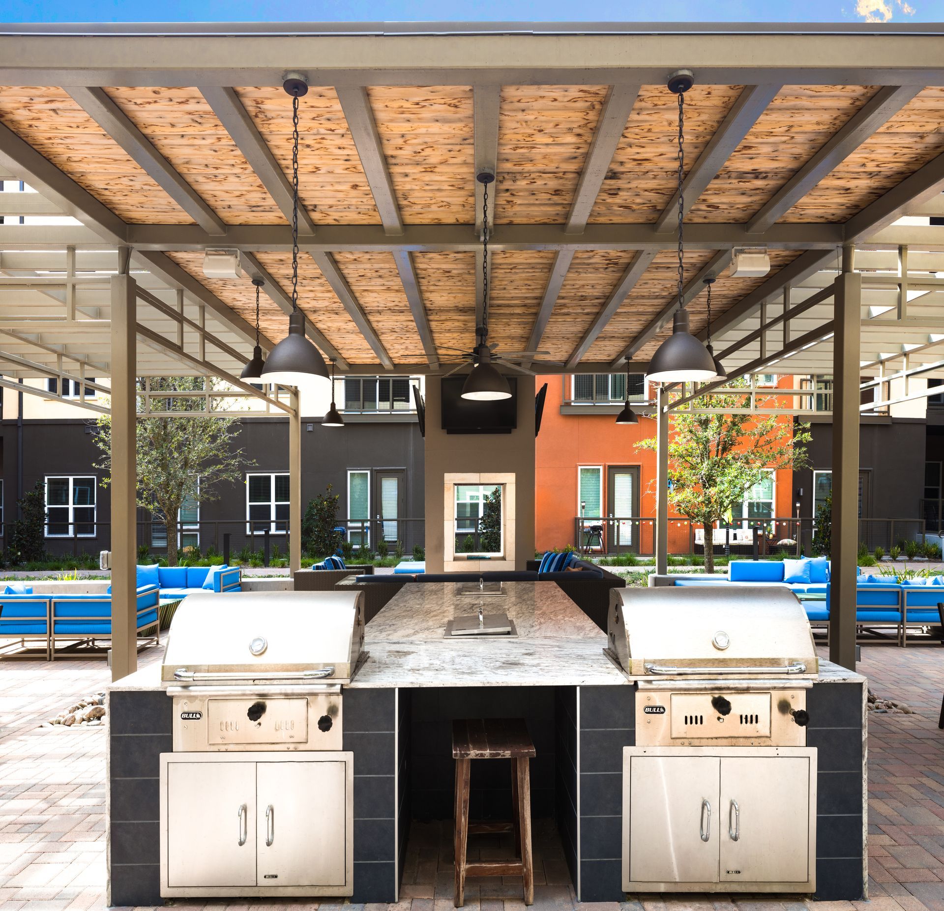 An outdoor kitchen with two grills under a pergola at Parkside at Craig Ranch.