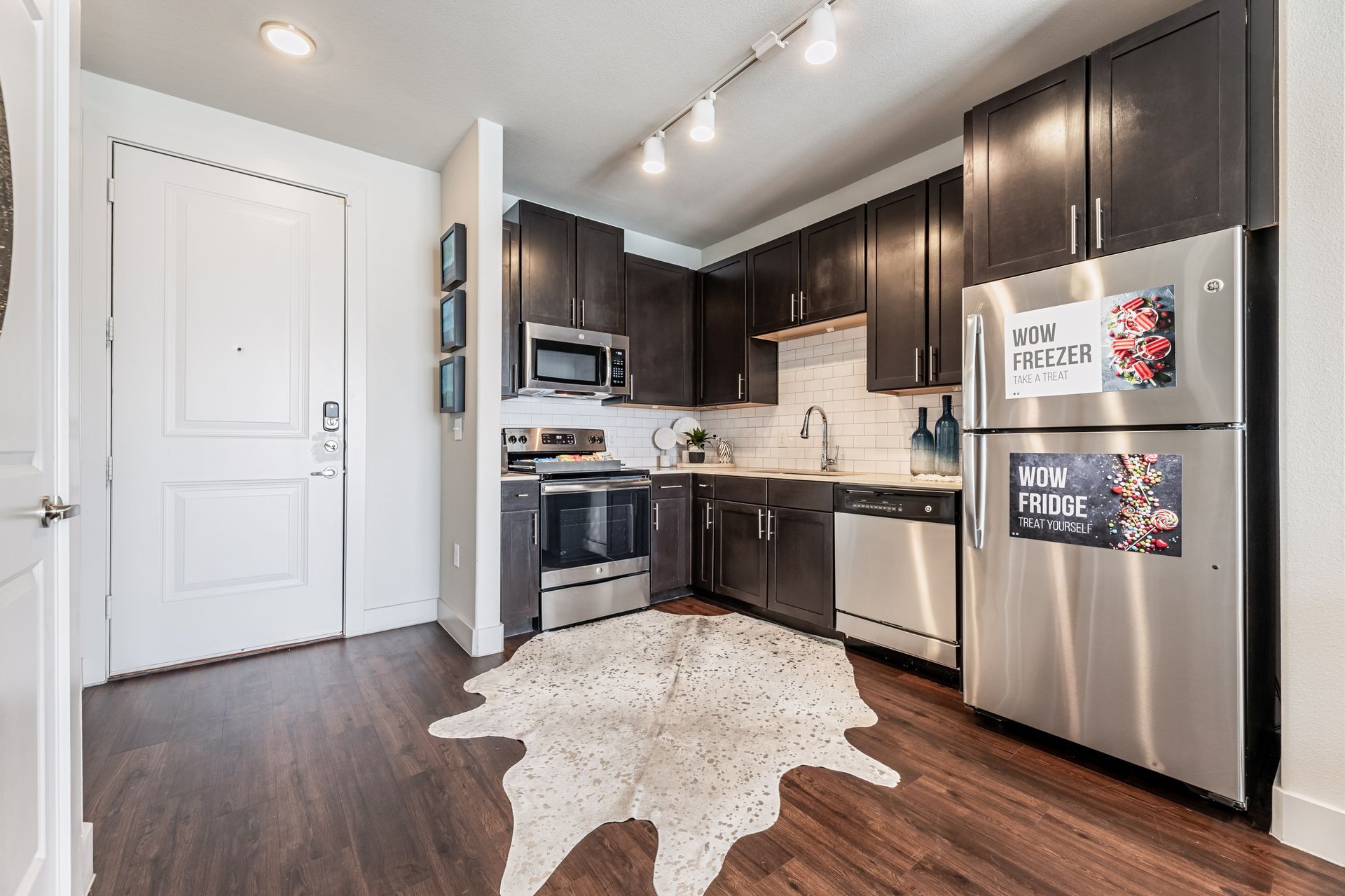 A kitchen with stainless steel appliances and a cowhide rug on the floor at Parkside at Craig Ranch.