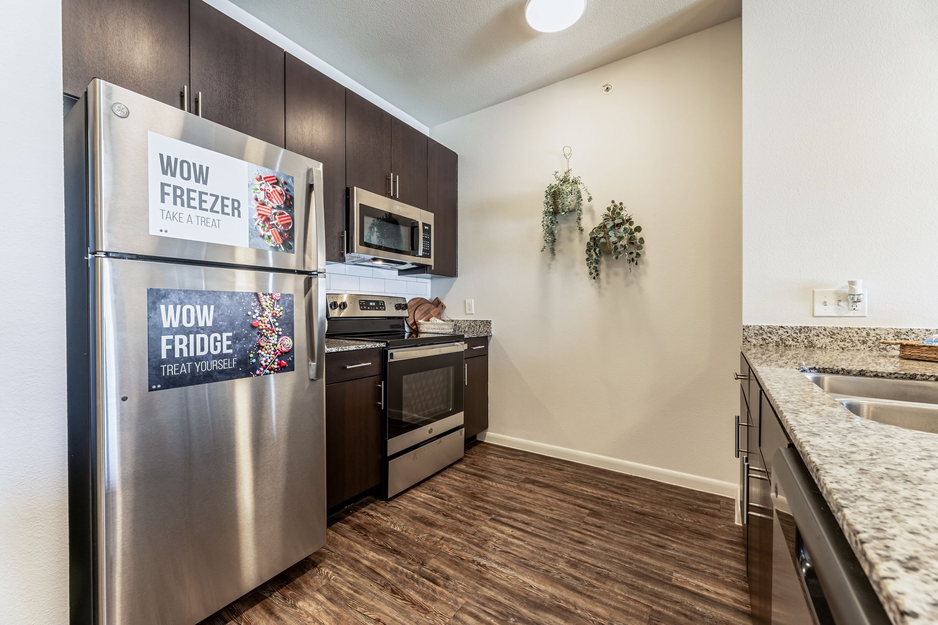 Apartment kitchen with stainless steel appliances and granite counter tops at Parkside at Craig Ranch.