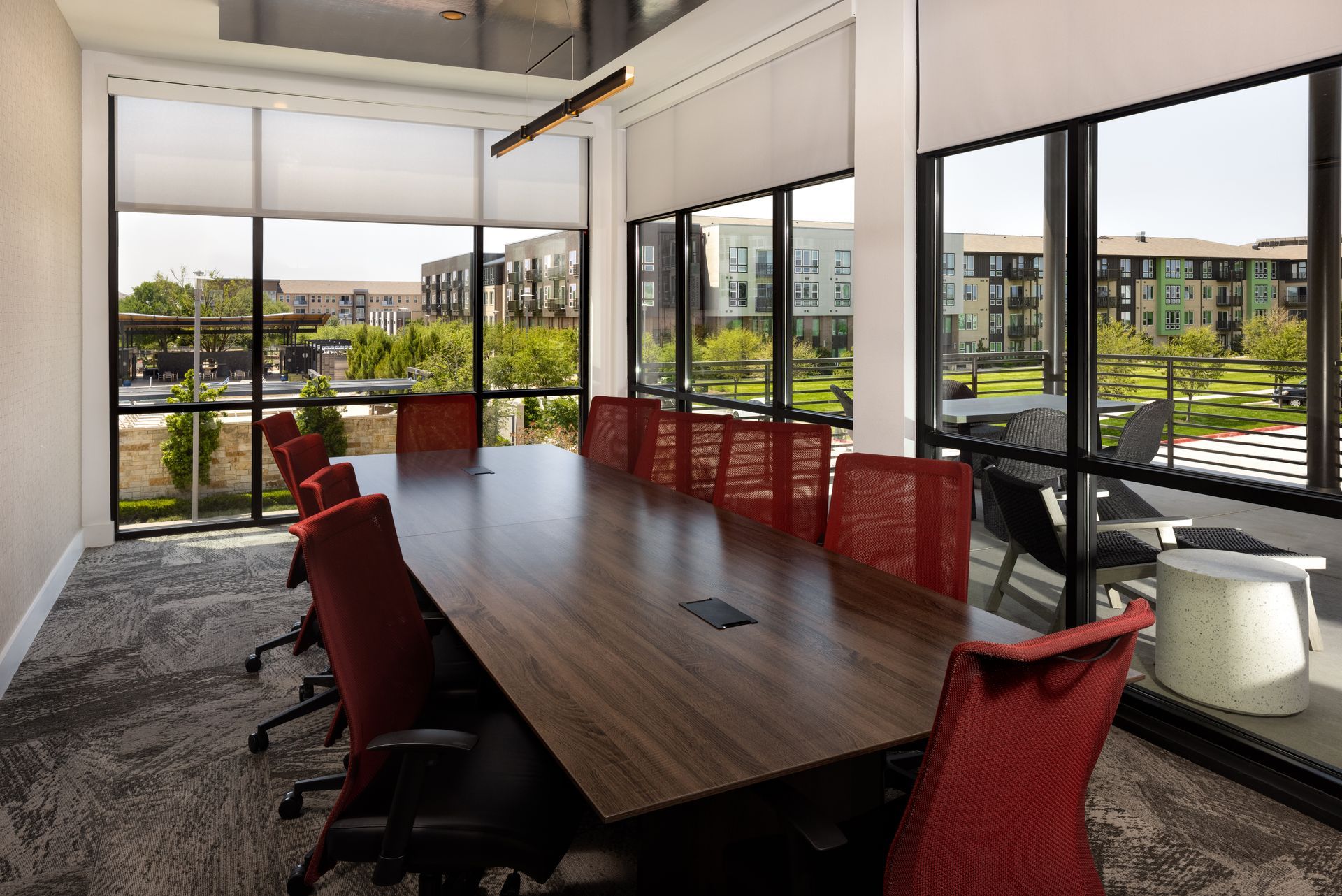 A conference room with a long table and red chairs at Parkside at Craig Ranch.
