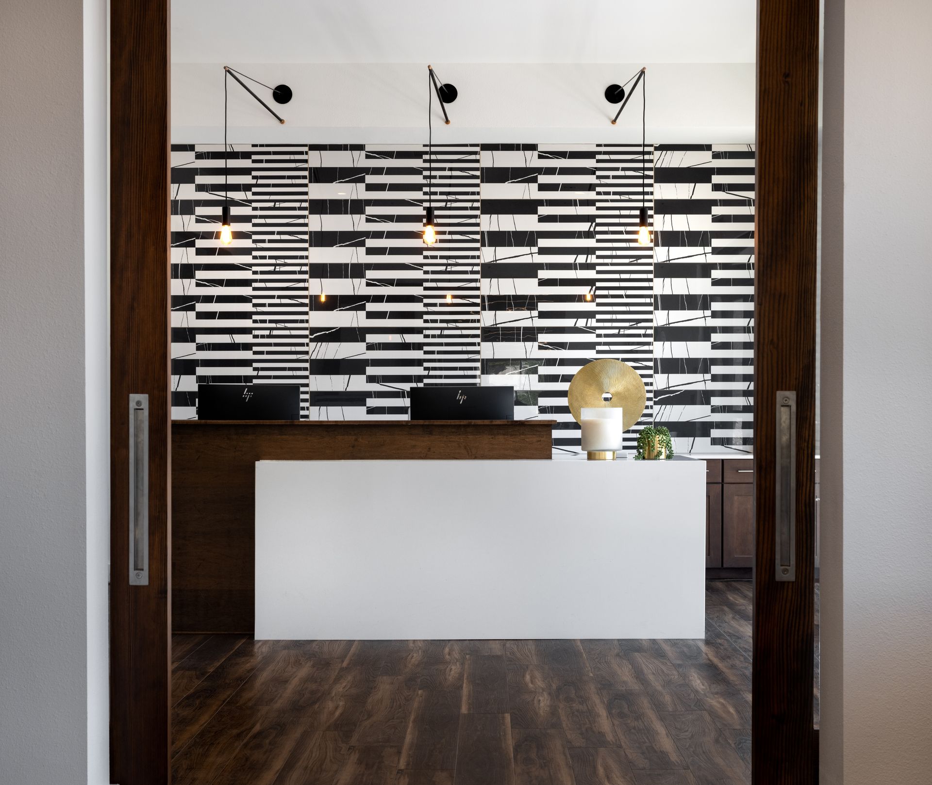 A black and white striped wall behind a reception desk at Parkside at Craig Ranch.