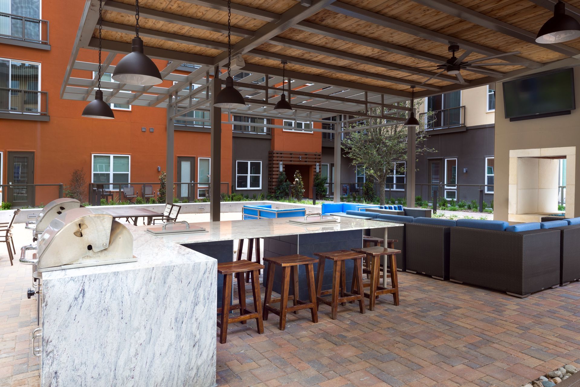 A large patio area with a grill and stools at Parkside at Craig Ranch.