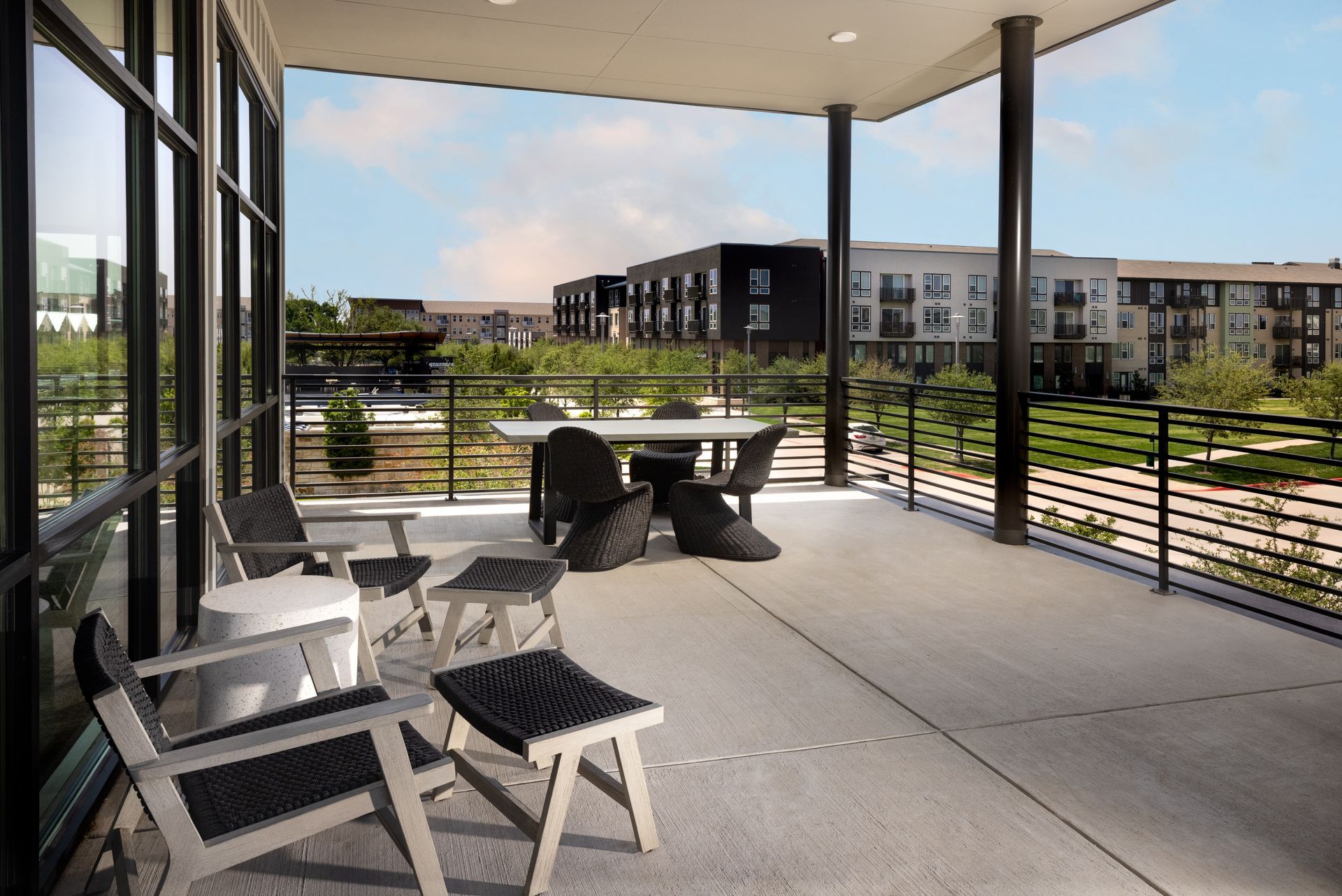 A balcony with chairs and a table with a view of a city at Parkside at Craig Ranch.