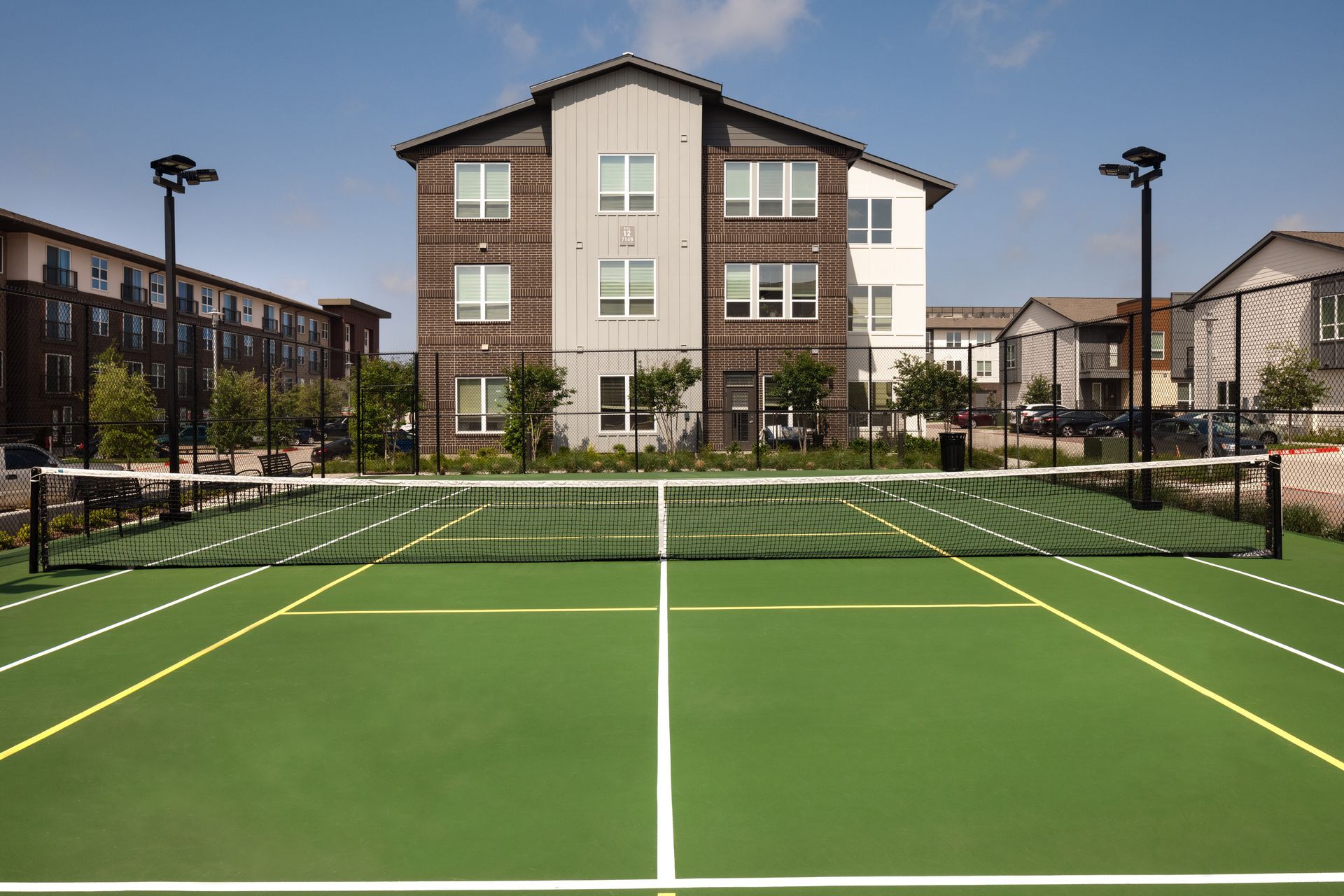 A tennis court with a building in the background at Parkside at Craig Ranch.