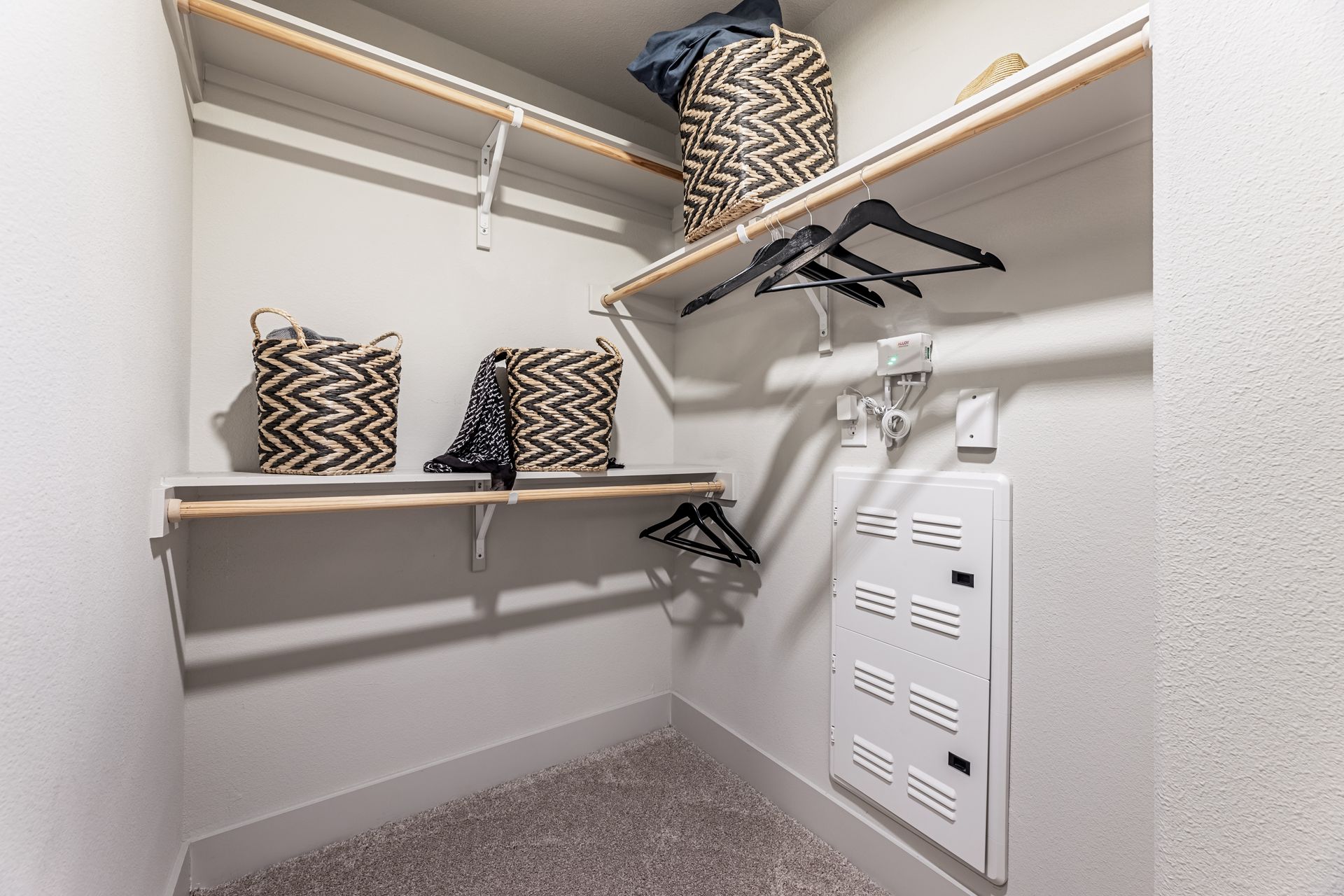A walk-in closet with shelves, baskets, and clothes hangers at Parkside at Craig Ranch.