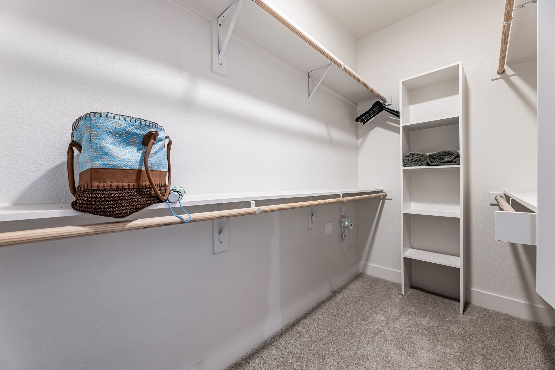 A walk-in closet with shelves and a basket on the shelf at Parkside at Craig Ranch.
