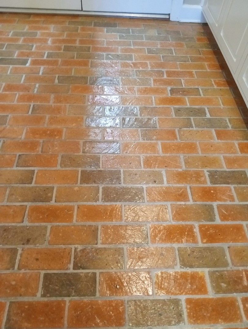 A close up of a brick floor in a kitchen.