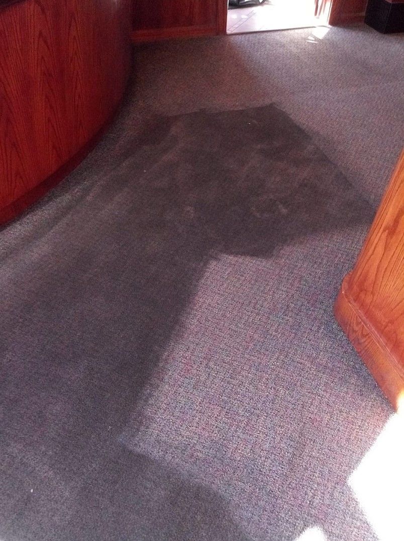 A shadow of a person is cast on the floor of a room.