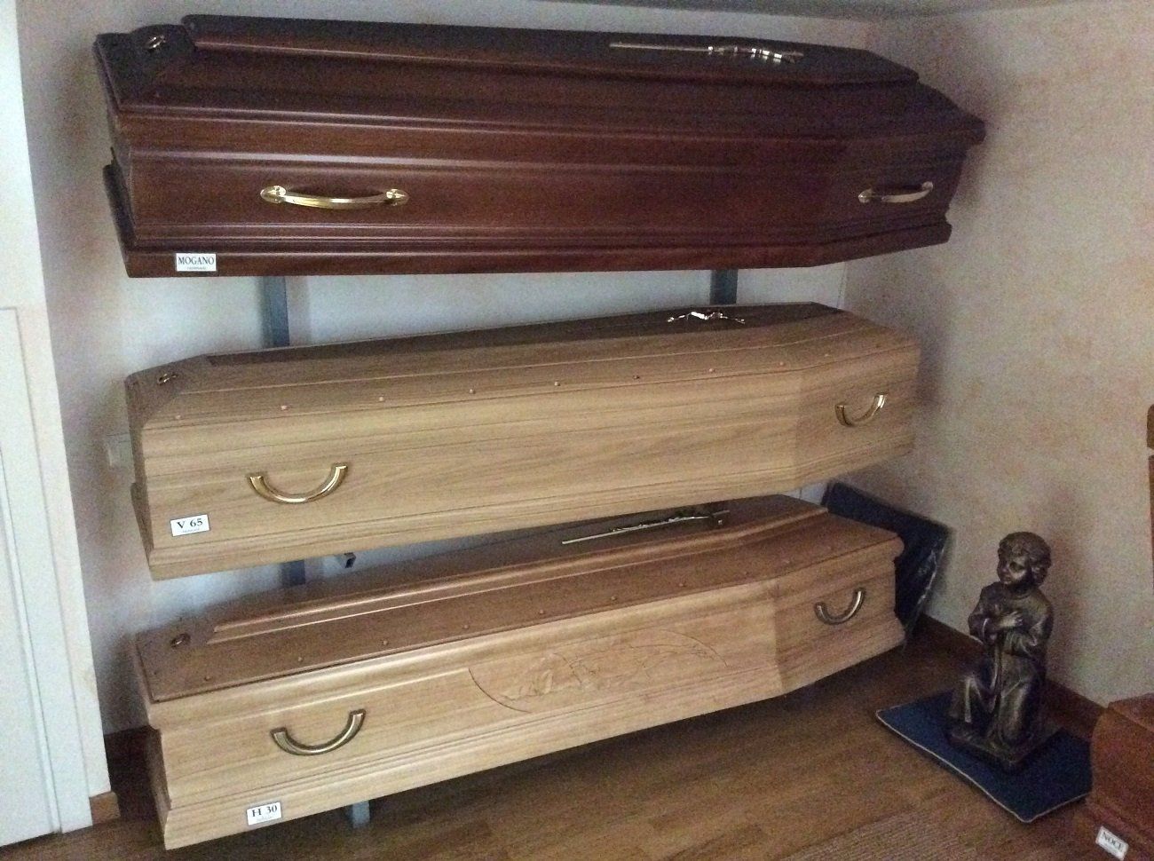 Tre bare di legno di diverse tonalità esposte su una parete.