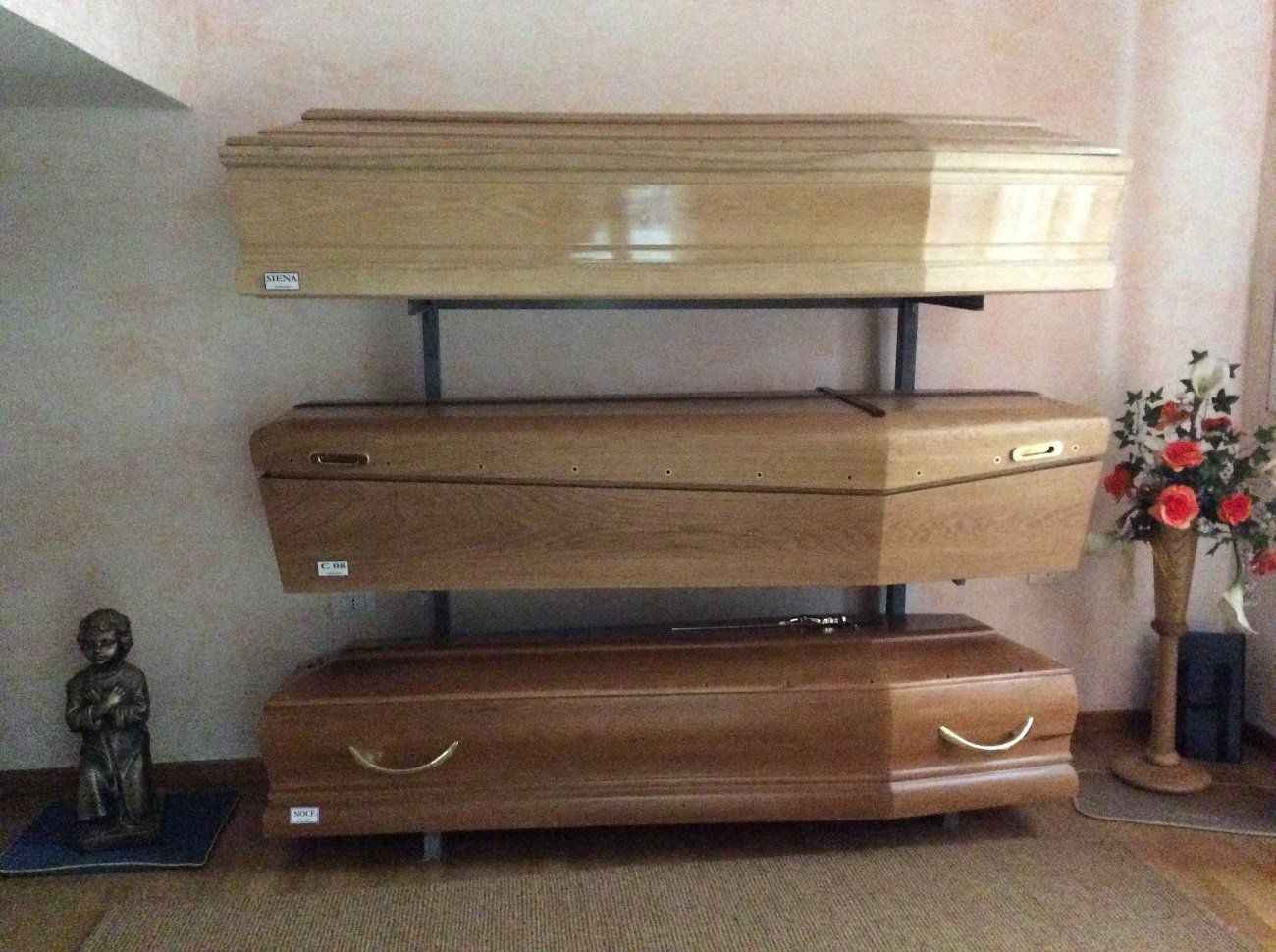 Tre bare di legno esposte in una stanza, di diverse tonalità di marrone.