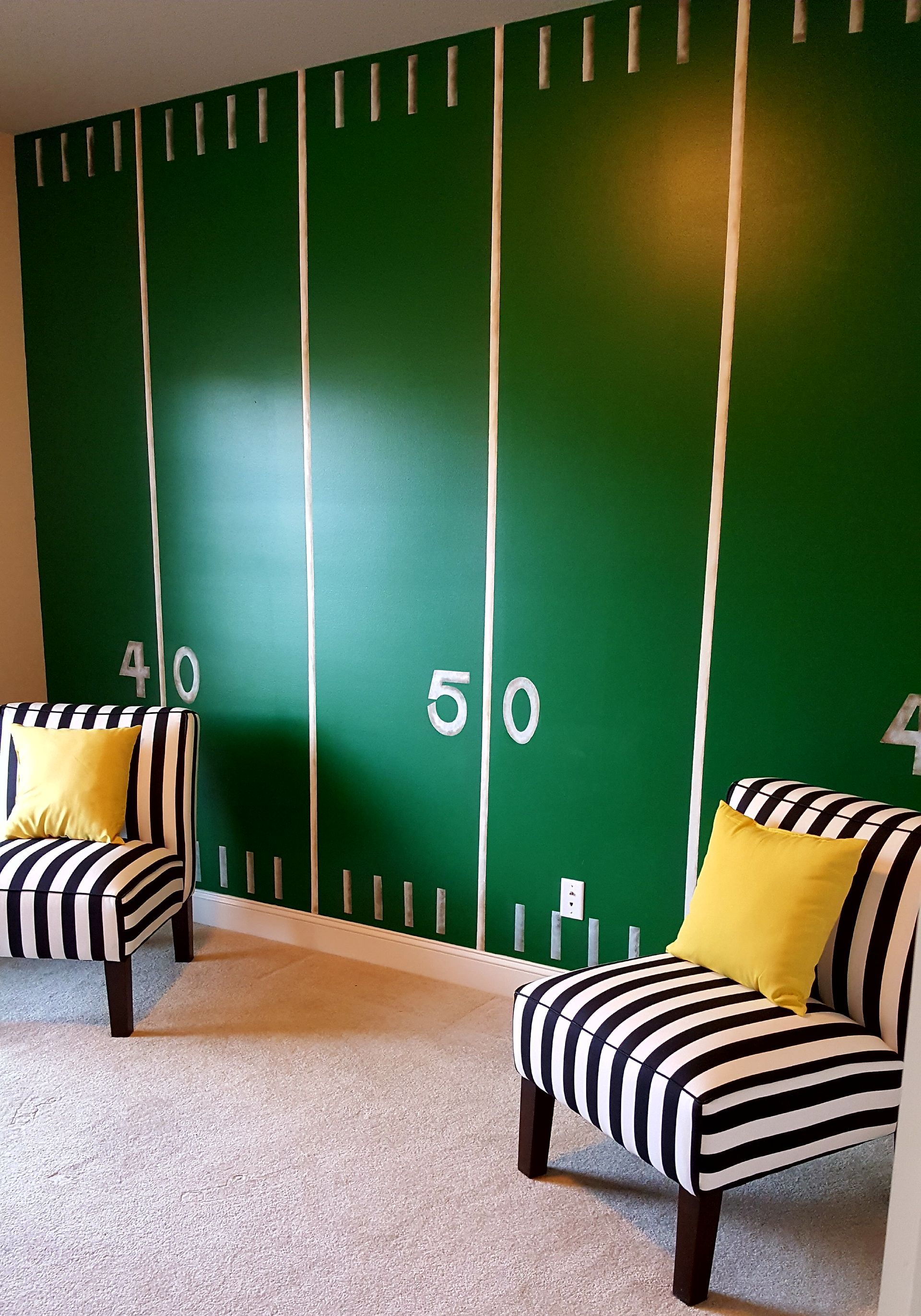 Two chairs are sitting in front of a green football field artist kids room